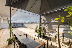 a patio with chairs and an umbrella on a roof at GuestReady - Terrace Cozy Stay in Coimbra