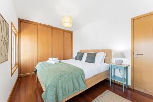 a bedroom with a bed with a green blanket at GuestReady - Terrace Cozy Stay in Coimbra