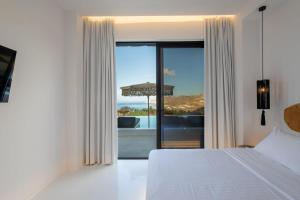 a bedroom with a bed and a view of the ocean at Aora Villa Ftelia Beach Mykonos in Panormos Mykonos +39 photos