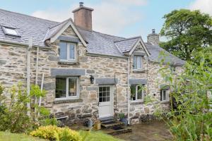 Capel GarmonSnowdonia Cottage 10 mins to Betws Y Coed的白色门的古老石头小屋