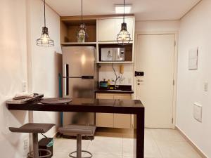 a kitchen with a desk and a refrigerator at Madrid 1101 in Sao Jose do Rio Preto