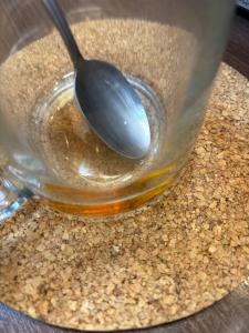 ein Löffel, der in einem Glas Honig liegt in der Unterkunft втулка in Bolʼshevik