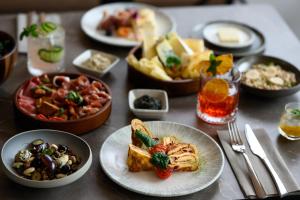 a table with plates of food and bowls of food at Hotel Lycium Debrecen - Handwritten Collection in Debrecen