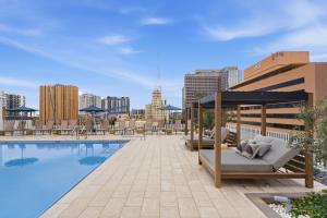 凤凰城Placemakr Downtown Phoenix的一座游泳池,毗邻一座建筑,设有凉亭