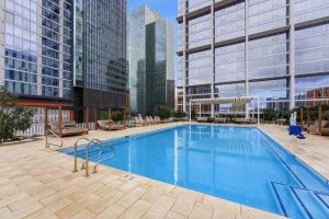a large swimming pool in a city with tall buildings at Placemakr Downtown Phoenix in Phoenix