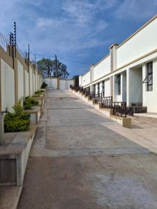 an empty alleyway between two buildings with benches at Mbuya Express Inn in Manzini