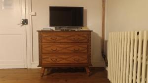 eine Kommode mit einem Fernseher darüber in der Unterkunft Aux vieux fours in Noaillac