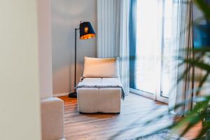 Habitación con silla, lámpara y ventana en Prázdninová rezidence - 2 ložnice, 2 terasy, 90m2, en Komárov