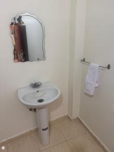 um banheiro branco com uma pia e um espelho em Hostel dallas Warzazate em Ouarzazate