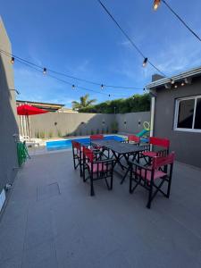 un patio con tavolo e sedie e una piscina di Casa 109 a Necochea Altre 11 foto