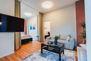 Una sala de estar con un sofá y un televisor. en Prázdninová rezidence - 2 ložnice, 2 terasy, 90m2, en Komárov