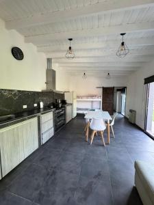 una grande cucina con tavolo e sedie bianchi di Casa 109 a Necochea