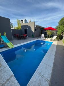 una piscina blu con uno scivolo in un cortile di Casa 109 a Necochea
