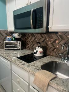 a kitchen counter with a sink and a microwave at Ocean Views steps to beach - Shoreline Stays 29 in Galveston