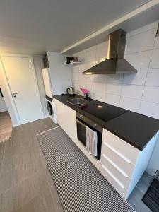 Una cocina con encimera negra y fregadero. en Apartment with open floor plan, en Gävle