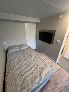 Un dormitorio con una cama y un televisor de pantalla plana. en Apartment with open floor plan, en Gävle