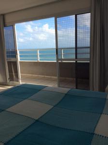 1 dormitorio con ventana grande con vistas al océano en Appartement Duplex, en Fortaleza