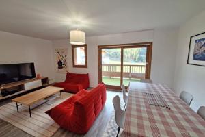 sala de estar con mesa y sillas rojas en Modern apartment in the heart of Séez, en Séez