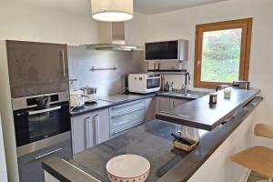 cocina con electrodomésticos de acero inoxidable y encimera en Modern apartment in the heart of Séez, en Séez 6 fotos más