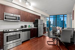 a kitchen with stainless steel appliances and a table with chairs at High Floor 1 Bedroom Condo City View Downtown Toronto in Toronto