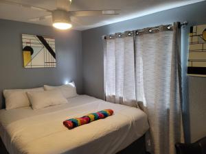 a bedroom with two beds with a rainbow pillow on the bed at Denver Layover B&B in DEN