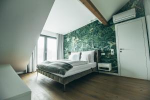a bedroom with a bed with a green wallpaper at Lenneapartments Premium in Plettenberg