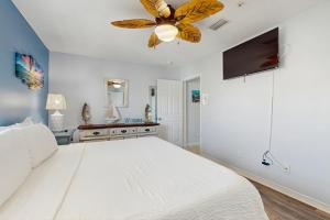 een slaapkamer met een wit bed en een plafondventilator bij Gulf Island Condo 523 in Navarre