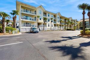een parkeerplaats voor een gebouw met palmbomen bij Gulf Island Condo 523 in Navarre