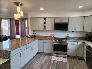 a kitchen with white cabinets and granite counter tops at Denver Layover B&B in DEN +15 photos