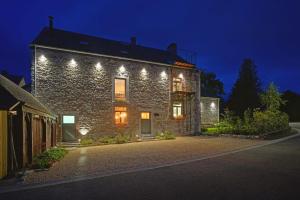 a stone house with lights on the side of it at La Forge - Chambres d'hôtes en Ardenne in Wellin