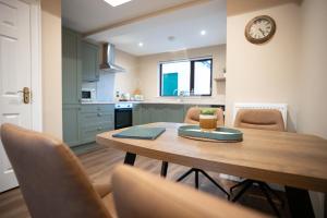 a kitchen and dining room with a table and a clock at Friels Terrace in Swatragh