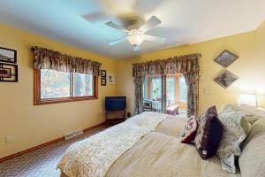 una camera da letto con un letto e un ventilatore a soffitto di Manitowish Mike’s a Manitowish Waters
