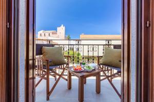 a balcony with two chairs and a table on a balcony at Mira Spiaggia in San Vito lo Capo