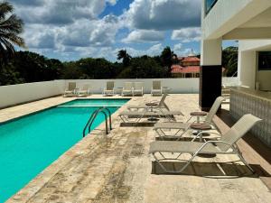 JuanDolio Penthouse 3 bedrooms Beachfront frente a hemingway في Los Corrales: مسبح مع كراسي صالة جلوس و مسبح