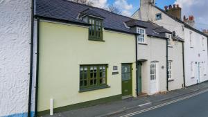 a white building with a green door on a street at Hafan in Beaumaris