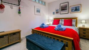 a bedroom with a red bed with red pillows at Hafan in Beaumaris