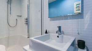 a white bathroom with a sink and a shower at Hafan in Beaumaris +41 photos