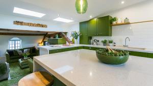 a kitchen with green cabinets and a bowl of fruit on a counter at Hafan in Beaumaris