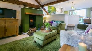 a living room with a fireplace and green walls at Hafan in Beaumaris