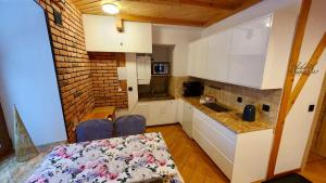 una cucina con mobili bianchi e un tavolo con sedie di Apartamenty SZUMiWODA a Karpacz Altre 18 foto