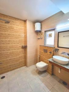 Un baño con un inodoro blanco y un lavabo. en Kommune Living, en Gurgaon