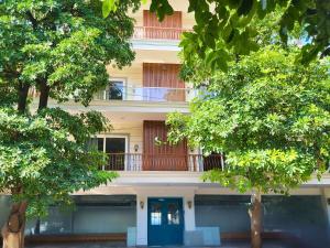 Un edificio de apartamentos con una puerta azul y árboles. en Kommune Living, en Gurgaon