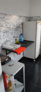 una cucina con bancone e frigorifero di Casa em Araçatuba-SP ad Araçatuba