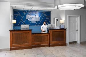 a man standing at a counter in a room at Holiday Inn Express Hotel & Suites St. Louis West-O'Fallon by IHG in O'Fallon +86 photos