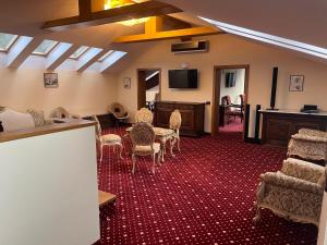 una camera con tavolo, sedie e televisore di Classic Inn Hotel by Radacini a Braşov