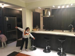 a woman standing in a kitchen with two stools at casa celeste in Puerto Montt