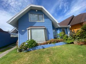 a blue house with a lawn in front of it at casa celeste in Puerto Montt
