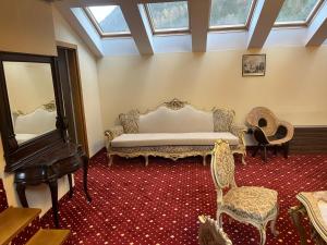 una camera con letto, specchio e sedie di Classic Inn Hotel by Radacini a Braşov