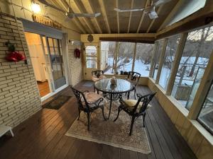 滨湖尼亚加拉Vintage Pines Guest House的带桌椅的封闭式门廊