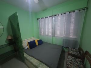 2 quadras praia da enseada guarujá região aquario في غوارويا: غرفة صغيرة بها سرير ونافذة +صورة واحدة